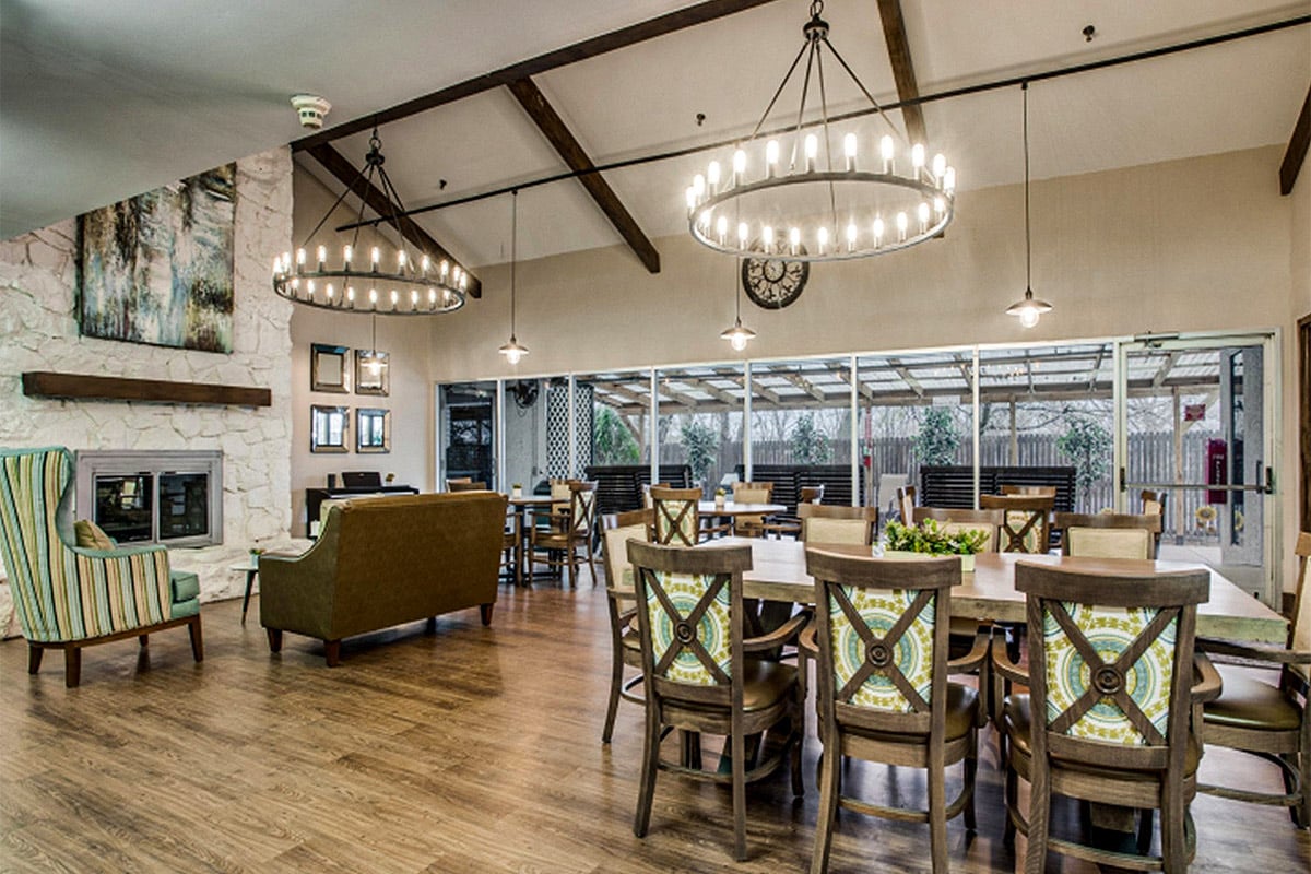 Common area with dining and seating with fireplace at Ennis Care Center